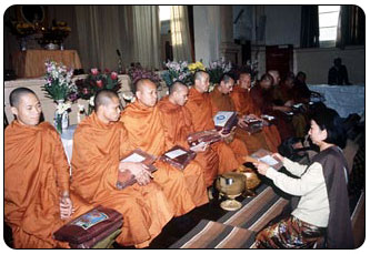 Offering robes to Theravadin monks at a Kathina ceremony.